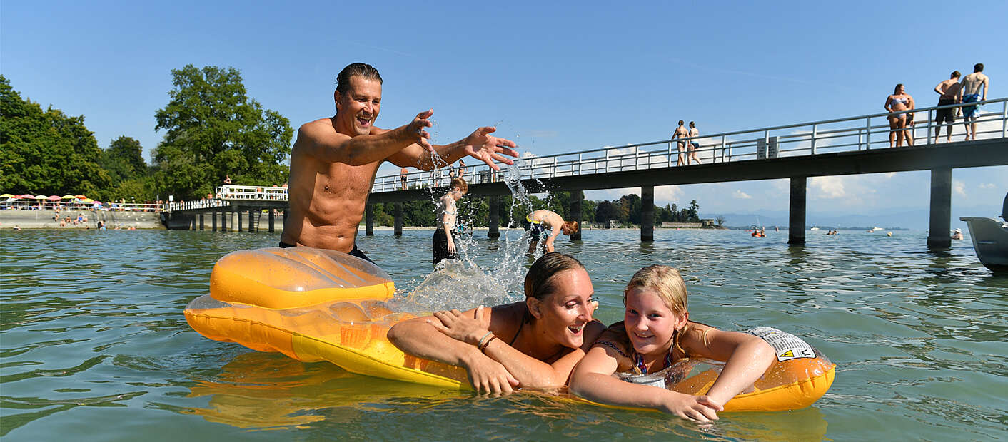 Familie planscht mit Luftmatratze im Bodensee